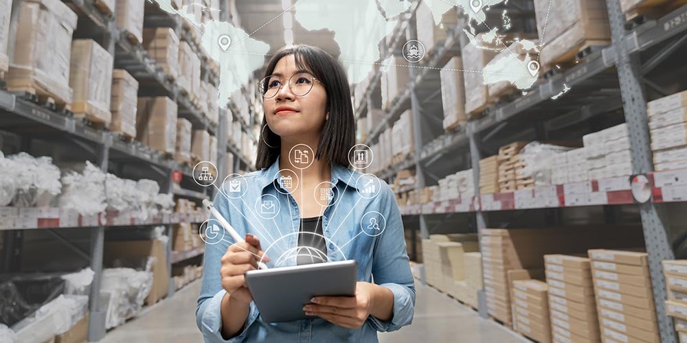 Women walking through warehouse, holding tablet while envisioning elements of supply chain.